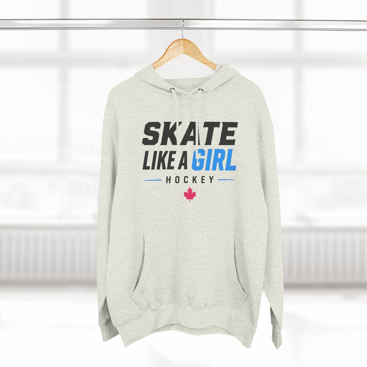 Skate Like A Girl Hockey hoodie in Oatmeal Heather hanging on a rack